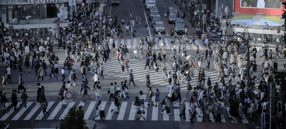 A busy intersection with people walking across in every possible direction