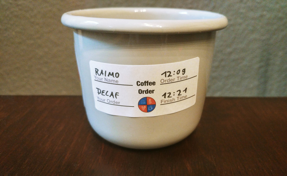 The cup we used for Coffee Kanban with an order sticker on it that has the name of the customer, their order, the start and finish time on it.